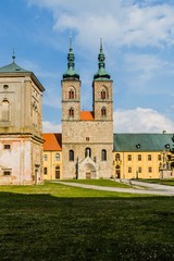 Tepla, Czech Republic / Europe - April 3 2019: Premonstratensian monastery founded in 12th century by Blessed Hroznata, abbey church made of stone with two towers, sunny day, blue sky, vertical image