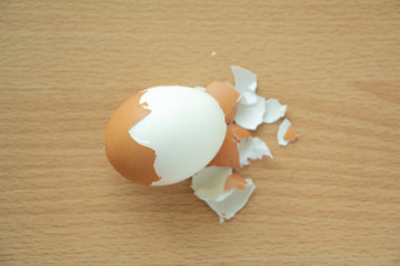 Peeled boiled egg on wooden table background.