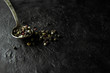 Spoon with allspice on a dark stone background
