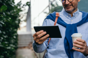 closeup man using tablet outdoor in the city