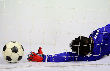 Soccer goalkeeper try to save to scoring goal against gray backgro