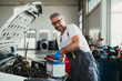 © cherryandbees - worker changing battery in car service