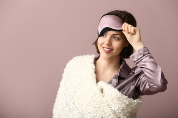 Sticker - Young woman with sleep mask and plaid on color background