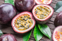 Passion Fruits And Its Cross Section With Pulpy Juice Filled With Seeds. Wooden Background.