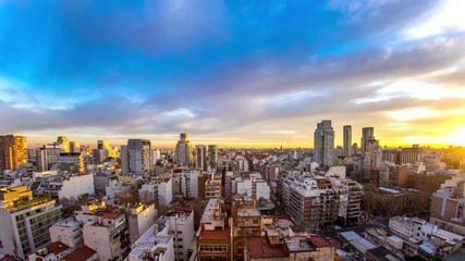 Wall Mural - Time-lapse view on the skyline of the city as colorful clouds pass by in the light of the setting sun in Buenos Aires, Argentina.