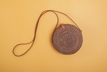 Wall Mural - Modern stylish round straw bag isolated on the yellow background