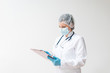© bnenin - Portrait of female doctor in protective wear looking at patient's chart.