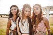 © Nabokov Alex - Three cute beautiful hippie girl in the setting sun, outdoors, the best of friends smiling and having fun, makeup, long hair, feathers in their hair, bracelets, flash tattoo, indie, Bohemia boho style