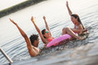 © BalanceFormCreative - Group of friends swimming and having fun in the lake.Female sitting on air mattress drinks lemonade and having fun with friends.