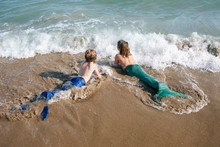Two Little Girls With Mermaid Swimwear At The Seashore