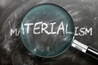 Learn, study and inspect materialism - pictured as a magnifying glass enlarging word materialism, symbolizes researching, exploring and analyzing meaning of materialism, 3d illustration