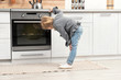 © New Africa - Little girl waiting for preparation of cookies in oven at home