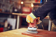 © astrosystem - Male carpenter using orbital electric sander in a retro vintage workshop.