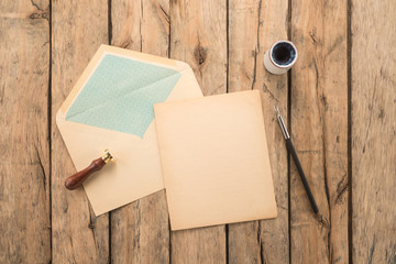 Wall Mural - Envelope, ink pen, inkwell, stamp on a wood table 	