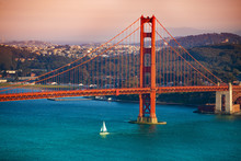 Yacht Passing Under Golden Gate Bridge At Sunset