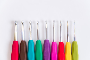 colorful crochet hooks on white background