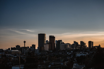 Wall Mural - Calgary skyline in the early morning with rays from rising sun reflecting off glass buildings.