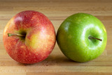 Fototapeta  - One red apple and one green apple on a wooden board