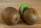 Fototapeta  - Kiwi fruit cut in half beside of another kiwi fruit