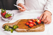© Branimir - Mother helps child to slice strawberry with knife