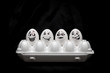 © Maxim - Real hand-painted eggs.  White eggs with faces drawn arranged in carton.Graffiti eggs in an egg box. Copy space. Black background.