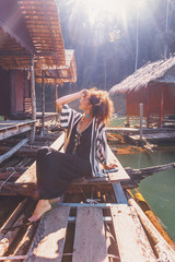 Wall Mural - beautiful young stylish boho woman at wooden floating village