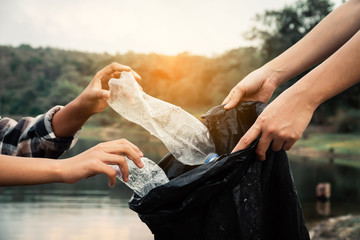 The volunteer picking up a bottle plastic in the river , protect environment from a water pollution concept.