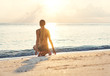 © mizuno555 - Young caucasian slender woman in swimsuit with blonde hair sits on the sandy beach at sunny morning