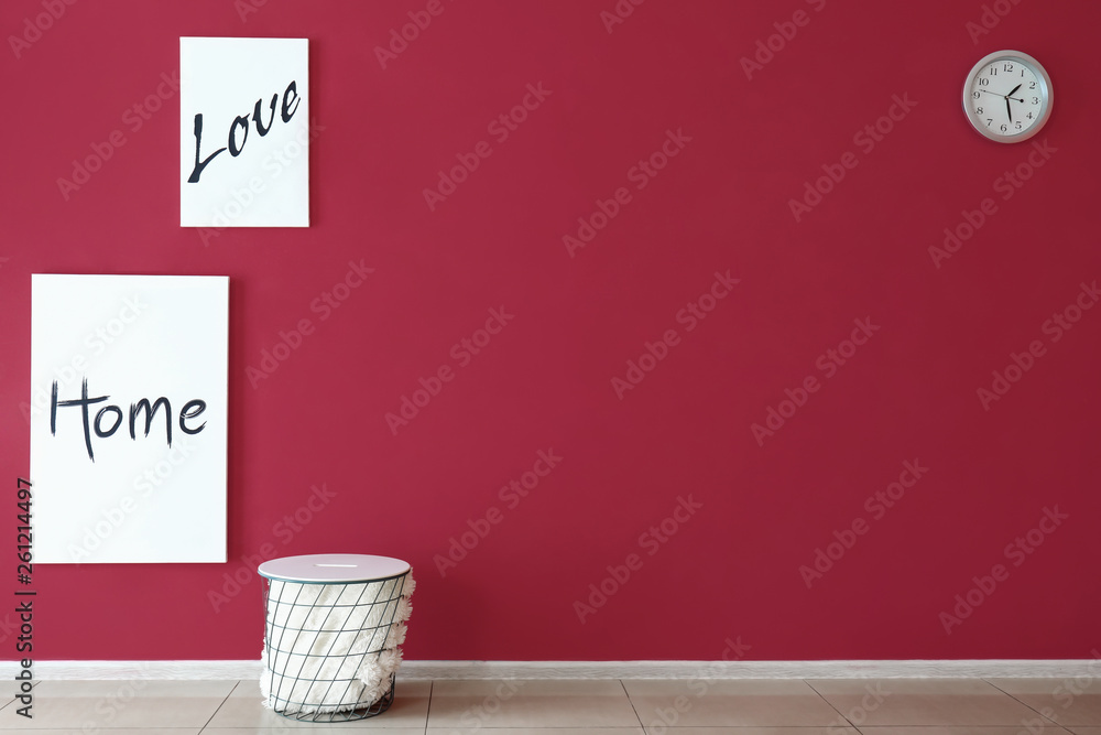 Basket with pictures hanging on color wall in room