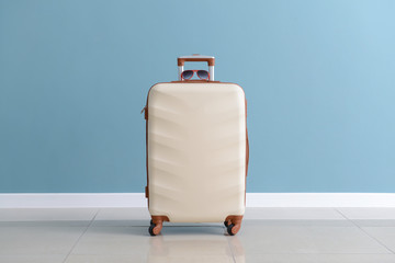 Packed suitcase near color wall