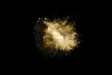 Golden Powder Explosion On Black Background. Freeze Motion.