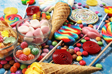 Wall Mural - candies with jelly and sugar. colorful array of different childs sweets and treats on blue