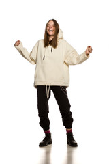 Wall Mural - Young happy model in hoodie on white background