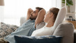 © fizkes - Peaceful man and woman relaxing leaning back on sofa