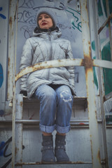 Wall Mural - Young woman on the staircase leading to the roof of the building. The concept of suicidal thoughts, female depression.