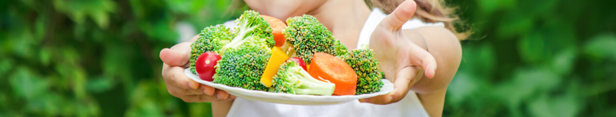 child eats vegetables. Summer photo. Selective focus.