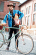 © rh2010 - Lifestyle portrait of a bearded hipster dressed stylishly with hat and jacket standing with retro bicycle on the urban background