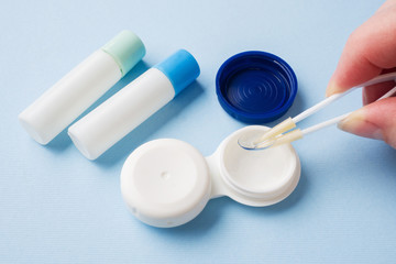 Wall Mural - Tweezers with contact lens and plastic container for lens storage. Close up. Selective focus.