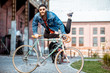 © rh2010 - Portrait of a bearded man as a crazy hipster having fun with retro bicycle outdoors on the industrial urban background