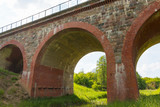 Fototapeta Na drzwi - Old arch railway bridge at sunny summer day