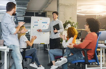 Wall Mural - Young millennial team analyzing information on graphs and charts