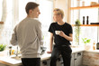 © Vasya - International gay couple in casual clothes in the morning at home in the kitchen