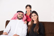 © Mahmoud Rahall - Arab family happy at home sitting on sofa chair