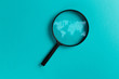 Concept information search. Magnifying glass with international map on blue background. World community and Neural network. New minimal creative concept. Searching information data on internet