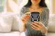 © Tierney - Online shopping theme with woman using her smartphone in a living room