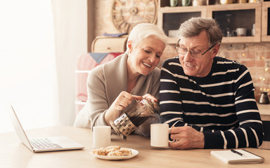 Wall Mural - Happy senior couple drinking tea in kitchen