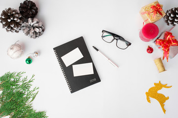 Flyer diary display on table with isolated white screen for mockup in Christmas time. Christmas tree, gifts, decorations in background.