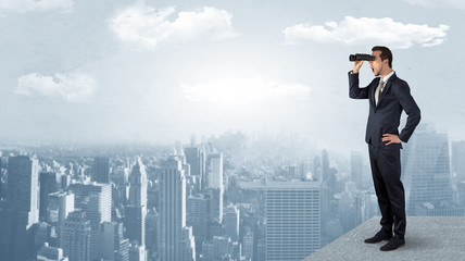 Wall Mural - businessman looking forward to a city with binoculars from skyscraper concept