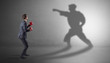 © ra2 studio - Businessman fighting with his strong karate man shadow