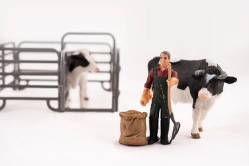 Toy farm. Miniature plastic cows and a worker.